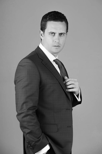 Pohledný podnikatel pózuje v Fialový oblek, bílou košili a kravatu - Fotografie, Obrázek