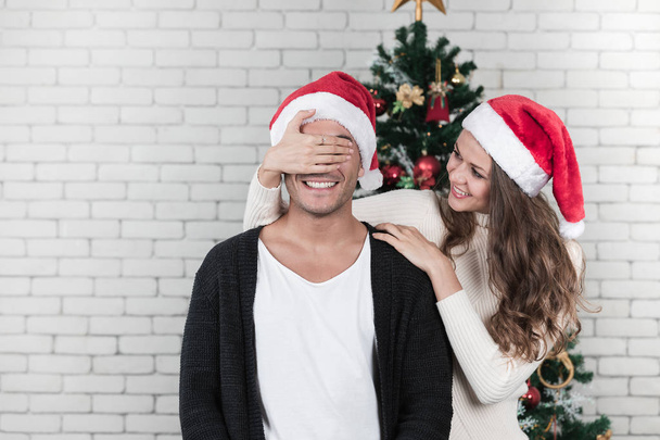 Young and beautiful caucasian woman standing behide beautiful woman and close his  eyes with smiling and happiness face of both together. Concept for good moment and sharing best time in christmas festival. - 写真・画像