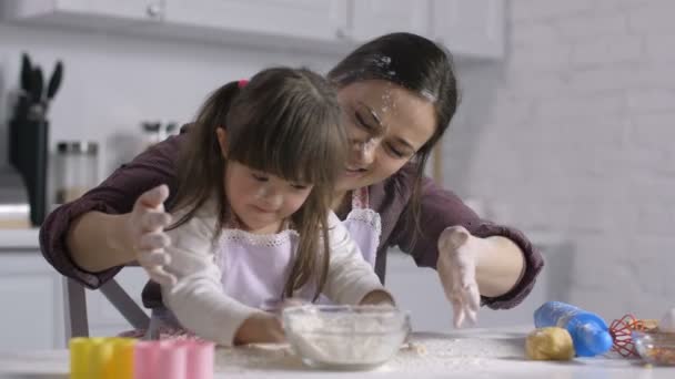 Mamá y su hijo con síndrome de Down jugando con harina
 - Metraje, vídeo