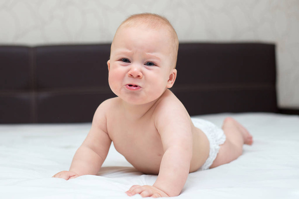 baby is learning to crawl on a bed at home - Zdjęcie, obraz