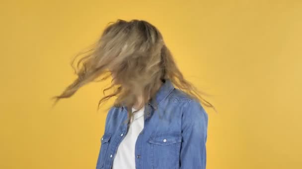 Nuori kaunis tyttö ravistelee päätään eristetty yli keltainen tausta
 - Materiaali, video