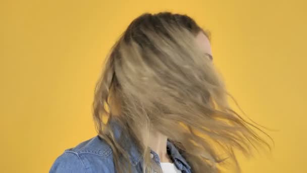 Szoros fel a fiatal szép lány rázza a fejét a sárga háttér - Felvétel, videó