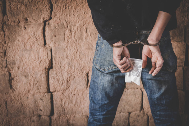 Huumekauppiaat pidätettiin heroiininsa kanssa. Poliisi pidätti huumekauppiaan käsiraudoilla. Laki ja poliisi konsepti, 26. kesäkuuta, kansainvälinen päivä huumeiden väärinkäytön ja laittoman kaupan torjumiseksi
 - Valokuva, kuva