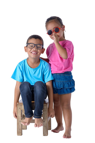 Portret van de kleine jongen en meisje is kleurrijk T-shirt met glazen geïsoleerd op een witte achtergrond met uitknippad - Foto, afbeelding