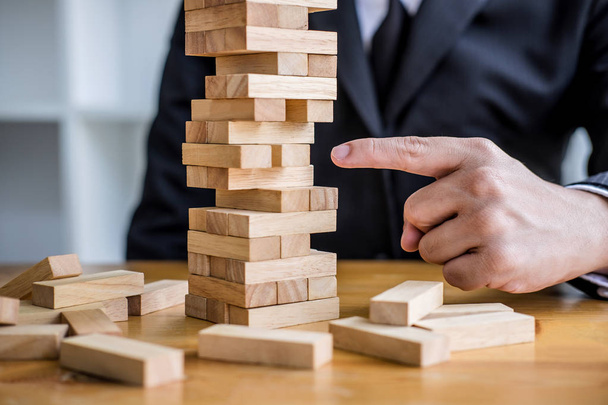 Alternative risk plan and strategy to growth profit in business, Young intelligent businessman playing the wood game, hands of executive placing wood block on the tower. - Fotoğraf, Görsel