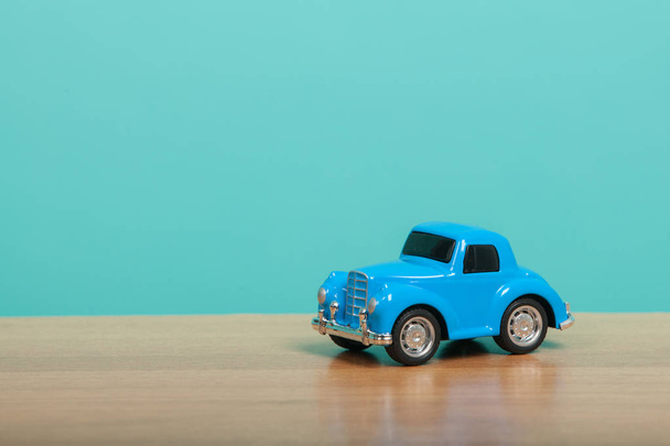 Симпатичный синий игрушечный автомобиль на зеленом фоне. Концепция путешествия
 - Фото, изображение