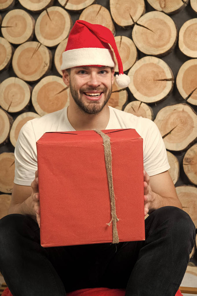 Macho in red hat smile with gift - Foto, afbeelding