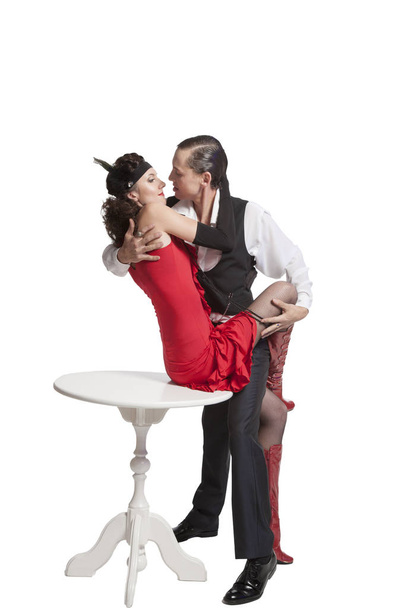 Jong koppel jongen en meisje in retro stijl een tango uitvoeren in een sexy pose gesneden op een witte achtergrond en elkaar hartstochtelijk te houden - Foto, afbeelding