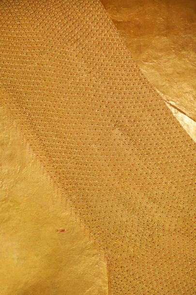 Cerrar hermosa textura brillo y patrón de túnica amarilla de brillante escultura buda de oro
. - Foto, Imagen