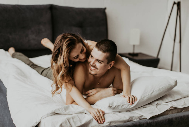 beautiful couple kissing in bed - Фото, изображение
