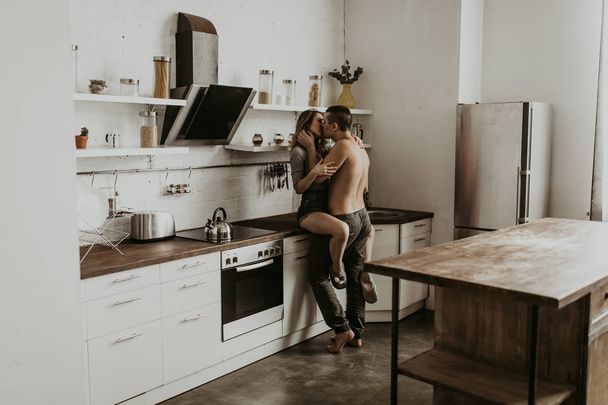 beautiful couple kissing in the kitchen - Foto, afbeelding