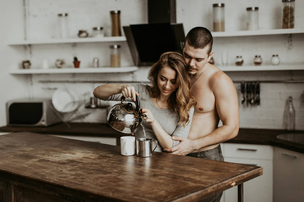 beautiful couple kissing in the kitchen - 写真・画像
