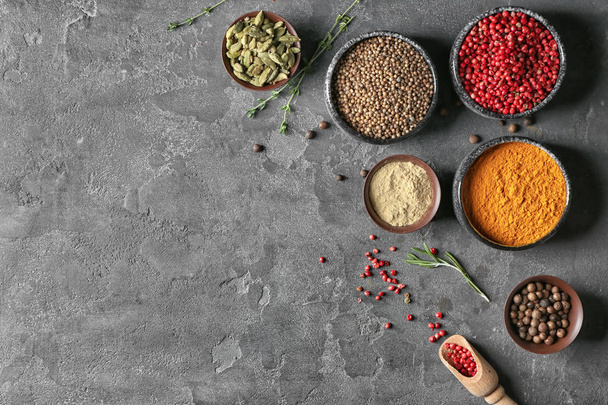 Bowls with different aromatic spices on grey background - Fotoğraf, Görsel