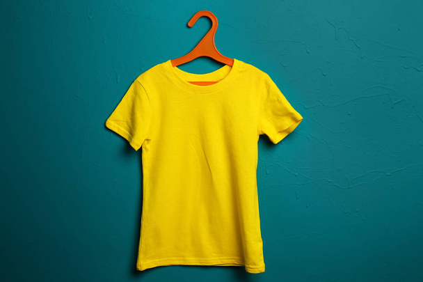 Дитяча футболка з вішалкою на кольоровому фоні
 - Фото, зображення
