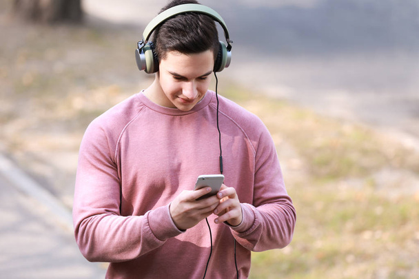 Jeune homme écoutant de la musique en plein air
 - Photo, image