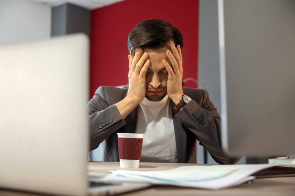 Stressed IT specialist missing deadlines in office - 写真・画像