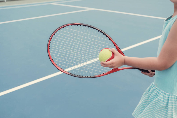 Youn girl tennis player on outdoor blue court  - Φωτογραφία, εικόνα