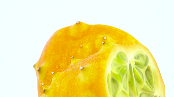 Macro shooting. Upper part of two halves of ripe kiwano fruit. Slowly rotating on the turntable isolated on the white background. Close-up. - Metraje, vídeo