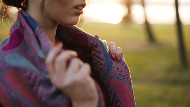 Vista de una chica toma de las manos en una bufanda y luego lo corrige en el soleado parque de otoño. 4K
 - Imágenes, Vídeo