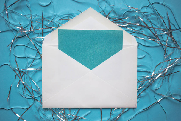Christmas composition. Envelope with a card. tinsel decorations on blue background. - Foto, imagen