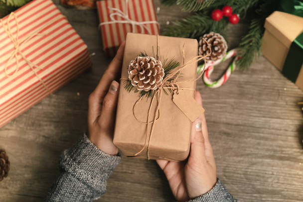 Noel ve yeni yıl kavramı için ahşap hediye kutusu tutunarak kadın el. - Fotoğraf, Görsel