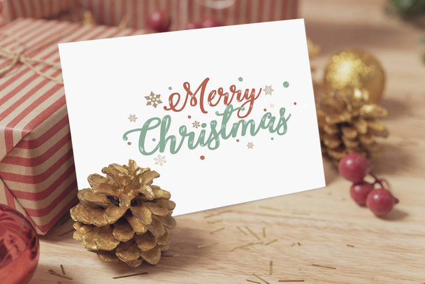 Christmas holiday greeting paper card design mockup with decoration on wood table. - Photo, image