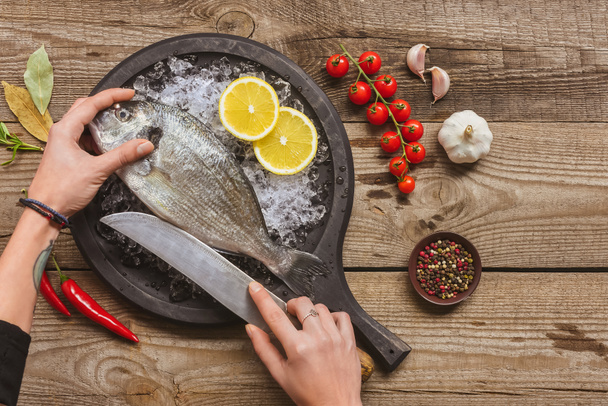 bıçak, ahşap masa üzerine dövmeli kadın kesme çiğ balık resim kırpılmış - Fotoğraf, Görsel