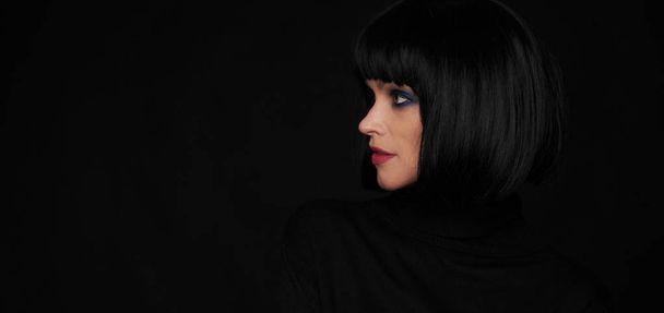 Profile portrait of a beautiful brunette woman over black background - Fotoğraf, Görsel