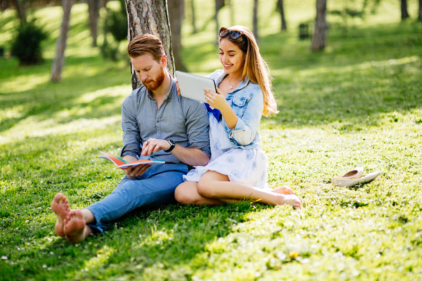 Cute university students studying and flirting in park - Valokuva, kuva