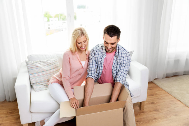happy couple with open parcel box at home - Photo, image
