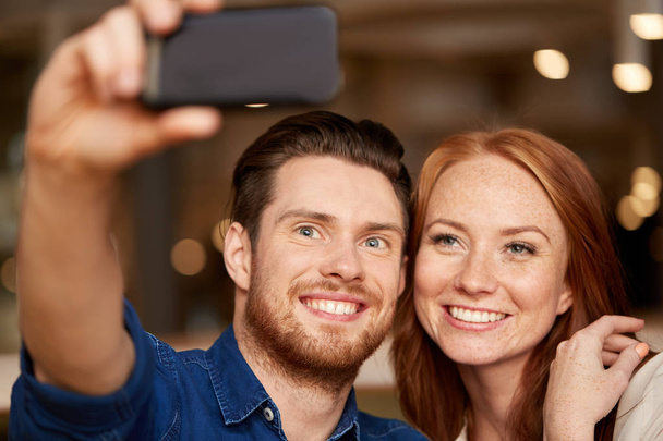 couple taking selfie by smartphone at restaurant - 写真・画像