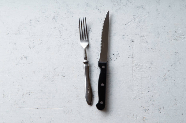 Couteau et fourchette sur fond de pierre de béton, vue de dessus
  - Photo, image