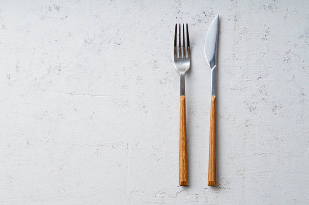 Knife and fork on concrete stone background, top view  - Zdjęcie, obraz