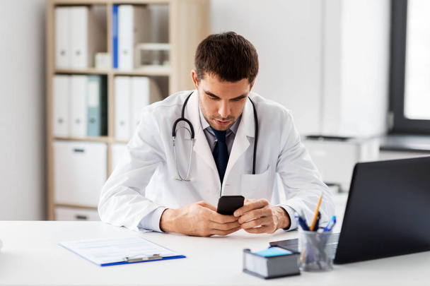 Doktor s smartphone v ordinaci v klinice - Fotografie, Obrázek