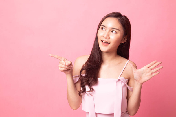 Excited Asian woman point to blank space on pink background - Фото, зображення
