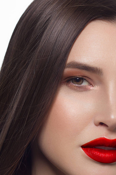 Close-up portrait of sexy european young woman model with classic glamour make-up and red lipstick. Dark long hairstyle, christmas makeup, dark eyeshadows, bloody red lips with gloss - Фото, зображення