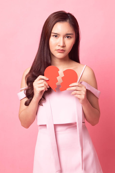 Beautiful young Asian woman with broken heart on pink background - Foto, imagen