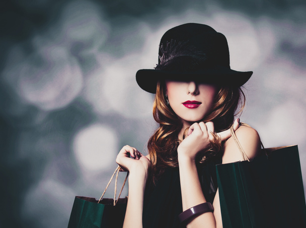chica en sombrero negro con bolsas de compras
 - Foto, imagen