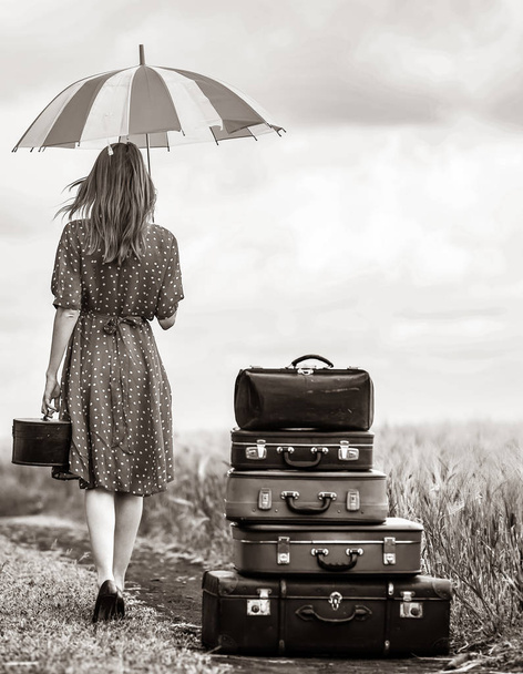 ragazza con valigie e ombrello su strada rurale durante il viaggio
 - Foto, immagini