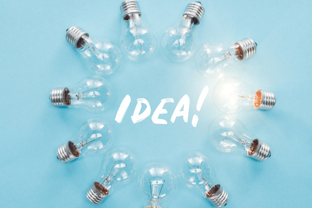 新しいアイデアのコンセプトを持つ、1 つ白熱の周辺 'アイデア' 単語と電球の輪 - 写真・画像