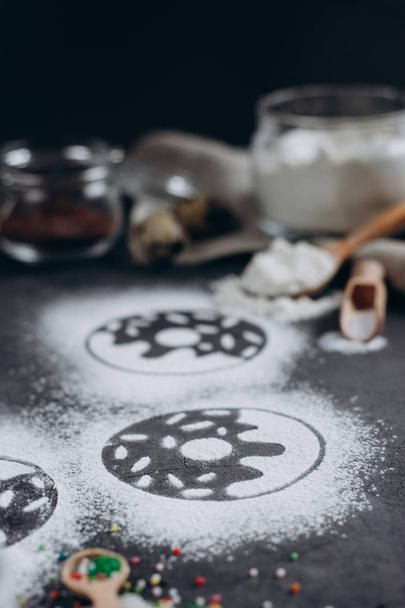 Ingredients for donuts baking. Spoon with flour, dishes, eggs, sugar  on a grey background.Bakery background frame. Top view, copy space. - Φωτογραφία, εικόνα