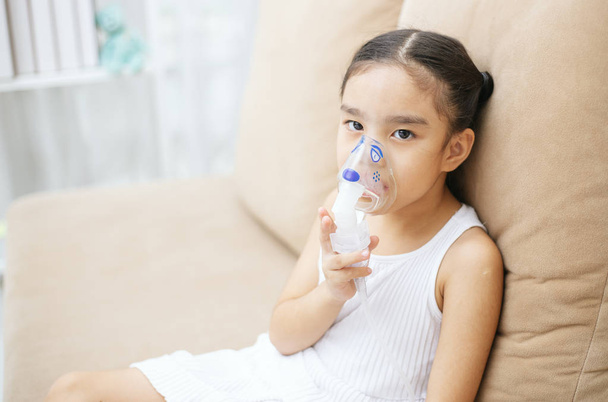 Lindo niño asiático paciente terapia de inhalación por la máscara del inhalador con humo de corriente suave de broncodilatador
. - Foto, Imagen