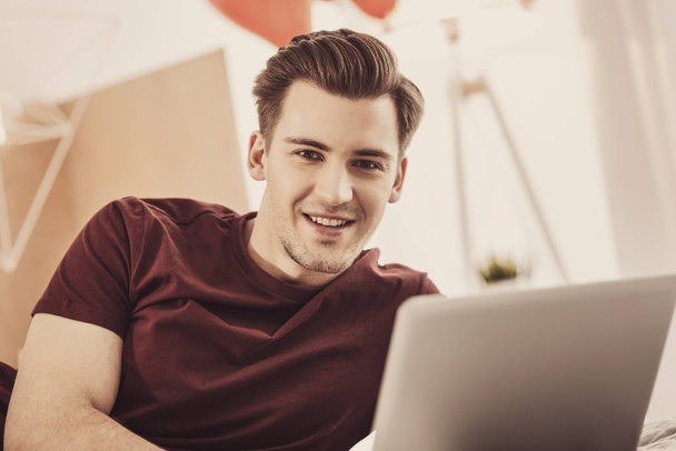 Young smiling man feeling excited while thinking about making surprise - Photo, Image