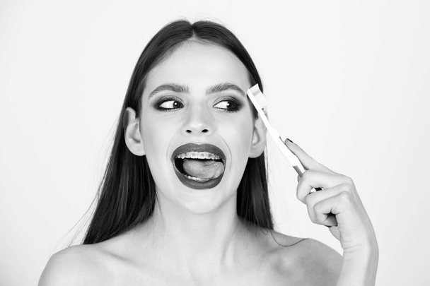 girl with teeth braces and brush, has fashionable makeup - Fotó, kép