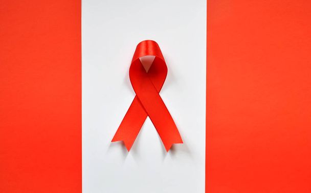 Beyaz zemin üzerine kırmızı kurdele. Dünya AIDS Günü kavramı. - Fotoğraf, Görsel