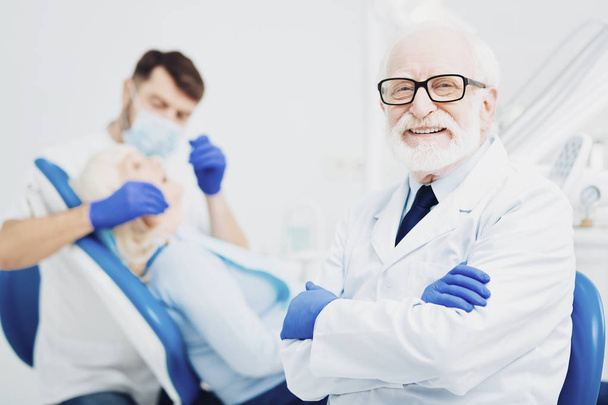Jolly male dentist working with colleague - Foto, imagen