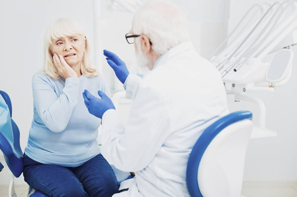 Sensitive male dentist consulting patient - Foto, Imagen