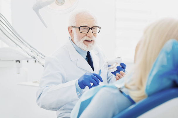 Successful male dentist explaining teeth cleaning - Photo, image