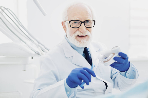 Experienced male dentist teaching right teeth cleaning - Фото, зображення