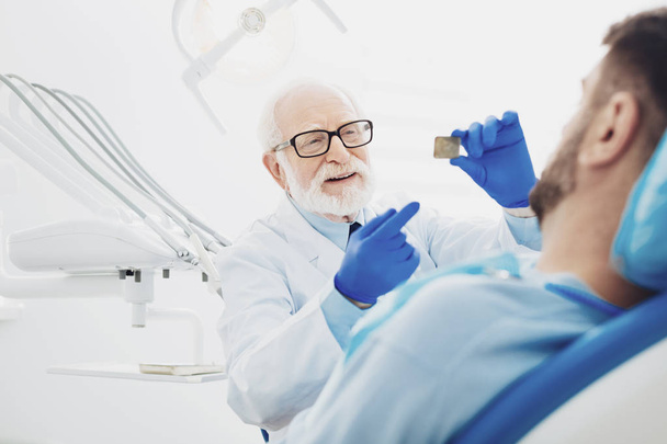 Thoughtful male dentist interpreting teeth radiography - Fotoğraf, Görsel